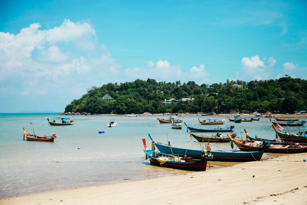 Traditional long-tail boats pulled up on a beach in Koh Samui ready for an island trip Traditional long-tail boats pulled up on a beach in Koh Samui ready for an island trip